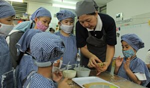 在大愛媽媽的帶領下，慈濟幼兒園全園師生合心和氣把素食便當盒一一完成。【攝影者：莊鞳勛】