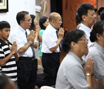 13歲的巫奕鵬（黑白線條衣服），跟著父親一起來禮誦地藏經，說要迴向給母親，因為母親工作太辛苦了。【攝影者：符詩健】