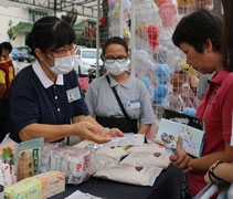 慈濟志工王秀謹（慮玟）向民眾許嬡珠介紹淨斯產品。她在試吃了淨斯月餅後認為：「它有點像冰皮月餅，可是我覺得，它比冰皮月餅還健康。」【攝影者：陳志財（濟庭）】