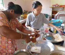 照顧戶瑟婉（左）在製作印度裔屠妖節糕點「姆魯古」（muruku）年餅。【攝影者：劉玲妹（慈畇）】