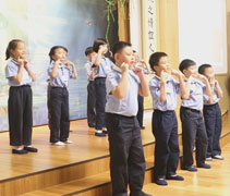 人文學校這一屆慈悲班(一到三年級)畢業生生動活潑的上台用手語表演《請 謝謝 對不起》這首歌要傳達的意境。【攝影者：丘笑菱】
