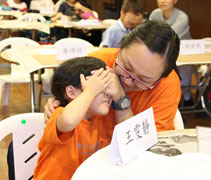 在畫畫之前，家長雙手蓋著孩子的眼睛讓孩子冥想與家長最美好的時光。【攝影者：陳慧潔】