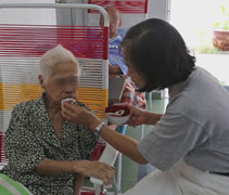 餵食老人家喝糖水時，慈濟師姊也細心幫助行動不便的老人家擦拭嘴唇，讓他們保持乾淨、衛生，減輕他們的負擔，能為別人服務，比被服務的人更有福。【攝影者：邢薇薇】