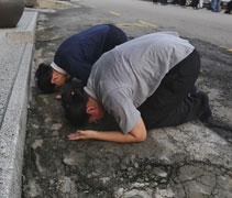 即使馬路坑坑洞洞、骯骯髒髒，菩薩們仍雙手貼地跪拜，不怕骯髒，一心一念完成朝山。【攝影者：邢薇薇】