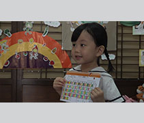 北海慈濟幼兒園學生黃鈺珍開心展示塗滿色彩的蔬果護照內頁，證明自己從未落下一餐素食。【攝影者：莊智文】